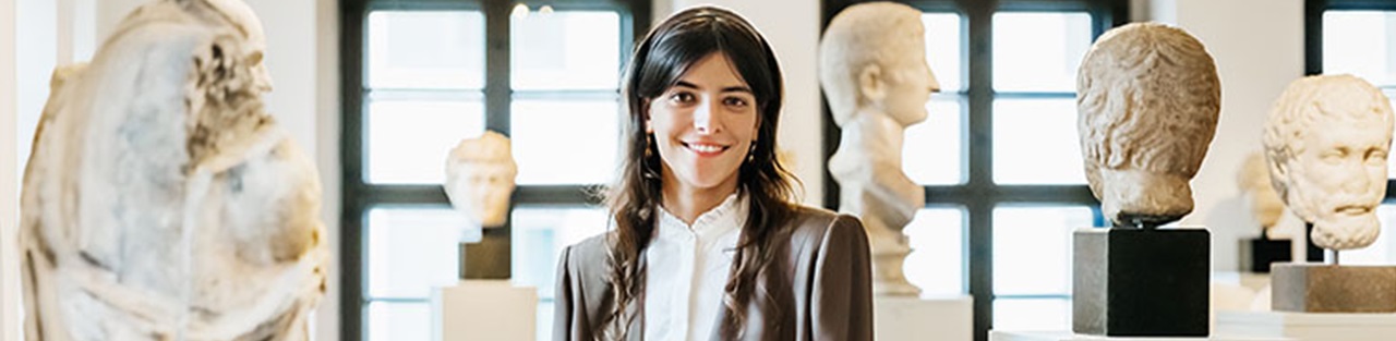 Woman in grey suit posing in museum