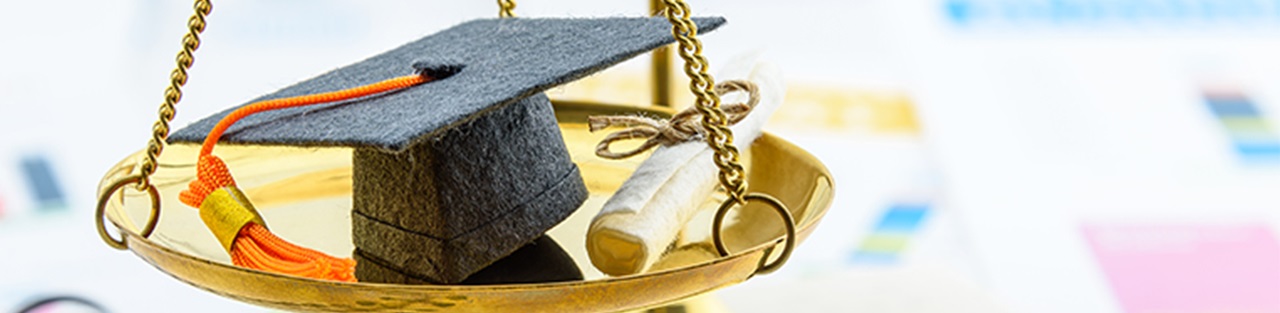 Graduate hat and degree in weighing scale