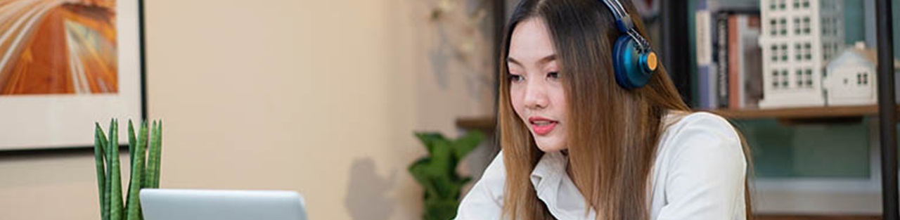 Woman wearing headset looking at laptop